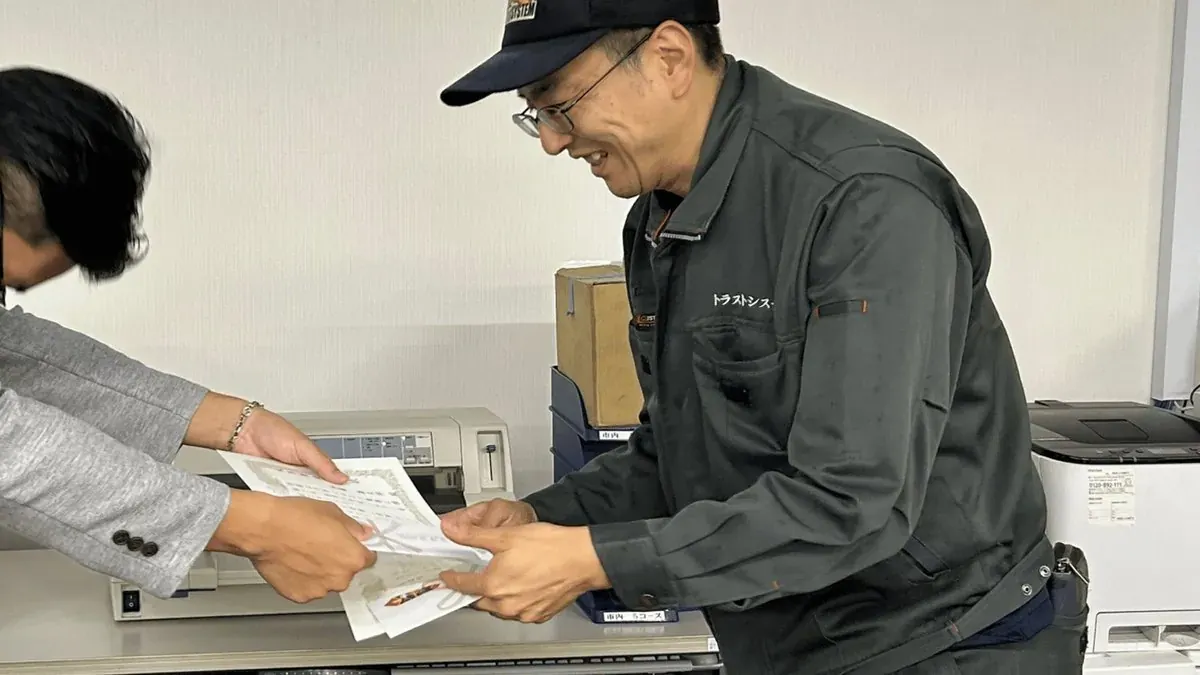 表彰状を手渡されるトラストシステムのドライバー